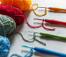 Colorful yarn balls and matching crochet hooks laid out—core contents of a beginner crochet kit.