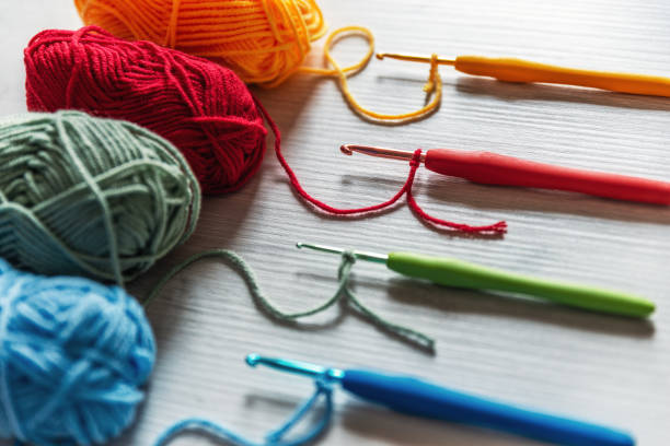 Colorful yarn balls and matching crochet hooks laid out—core contents of a beginner crochet kit.