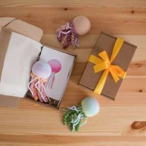 Colorful crochet jellyfish toys, some packaged, perfect for a beginner crochet kit.