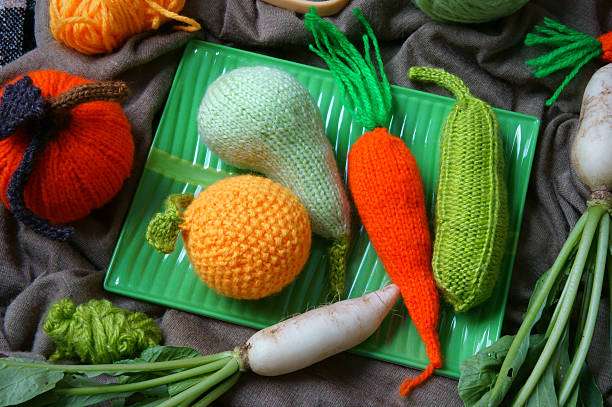Colorful crocheted vegetables display on a green tray, perfect for a fun Crochet Kit project.