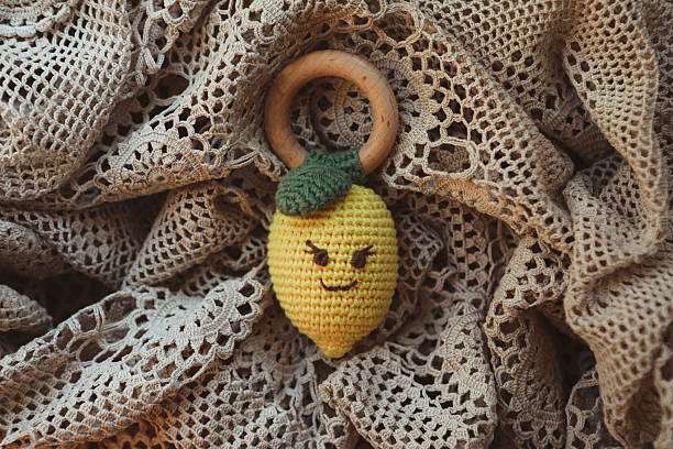 Cute crocheted lemon with a wooden ring, a sweet handmade item from a Crochet Kit.