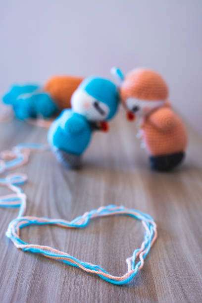 Two finished crocheted amigurumi toys and a heart of yarn, from a cute crochet kit.