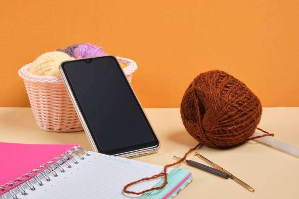 Yarn, hook, and smartphone, representing inspiration for a new Crochet Kit project.
